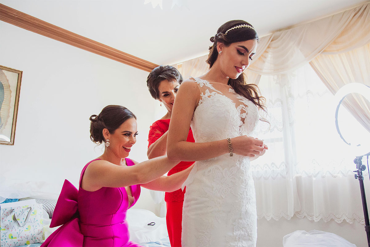 novia con su madre y hermana durante la prueba de vestido de boda